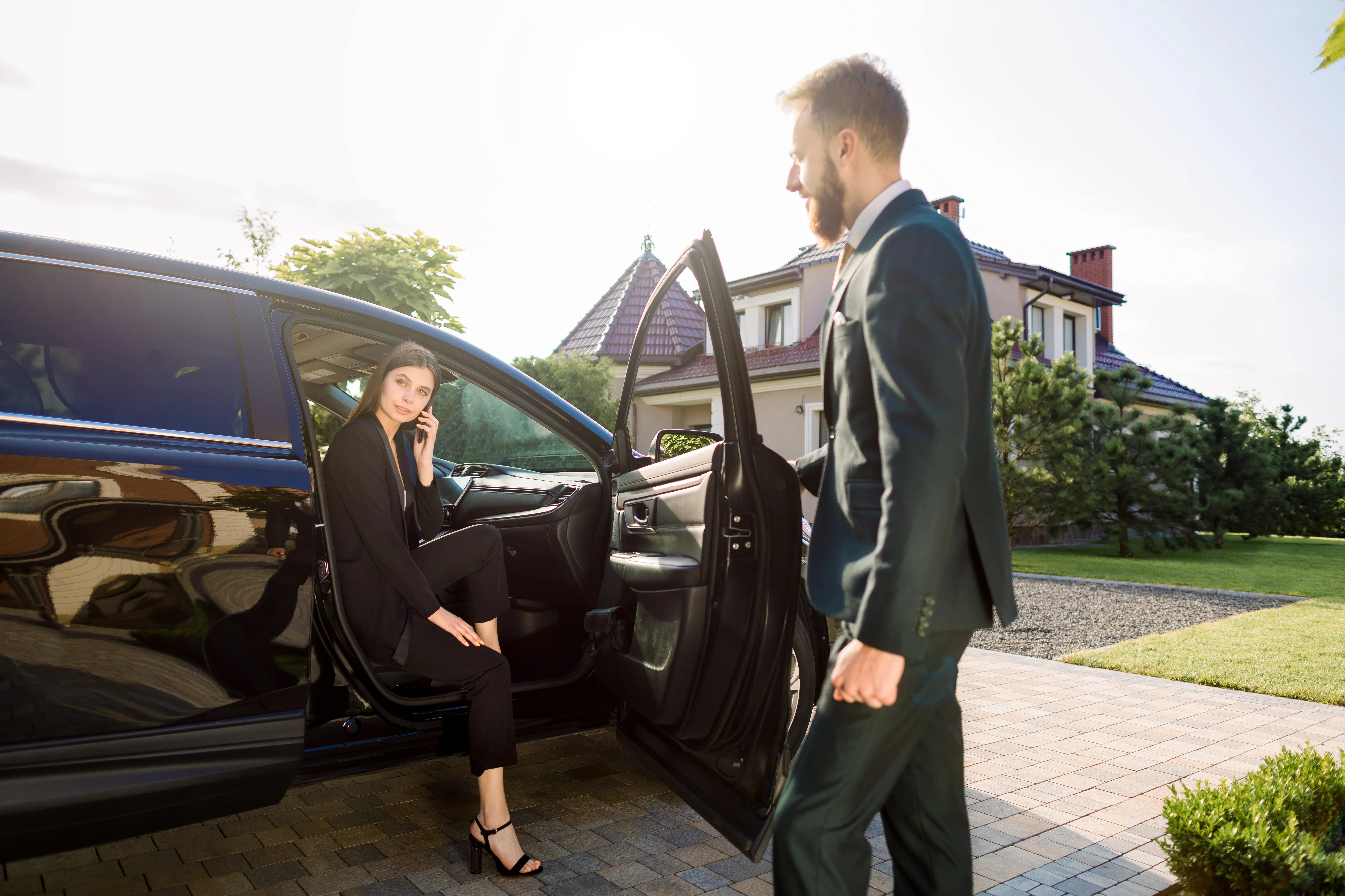 Luxury concierge services — chauffeur opening car door for client, representing white glove lifestyle management by Cadiz & Lluis